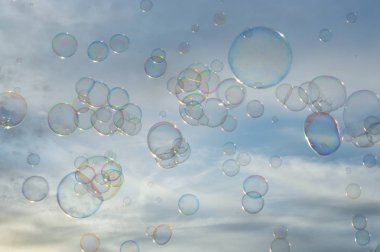 Günbatımı gökyüzü arka planında sabun köpükleri