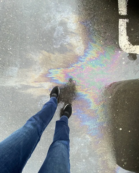 アスファルト上の女性の足や油流出のビュー — ストック写真