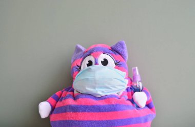 Cerrahi maske ve dezenfektan şişeli çizgili oyuncak.