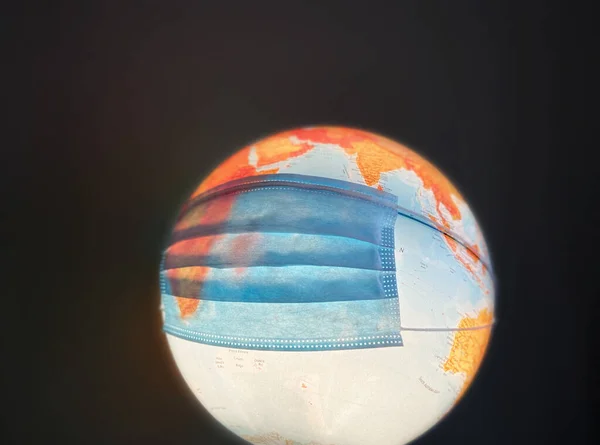 Image of earth globe with surgical mask
