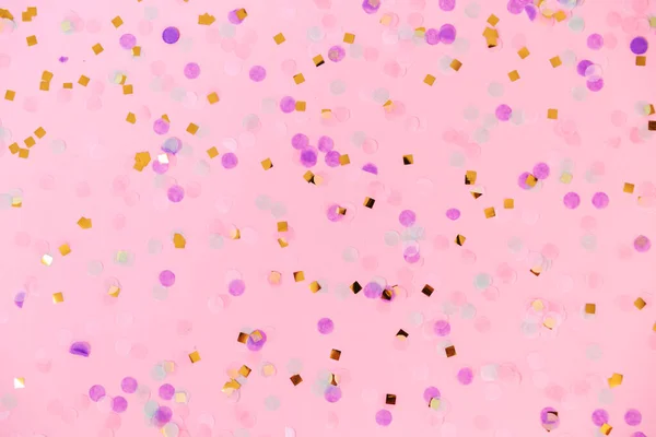 Confete multicolorido sobre fundo rosa . — Fotografia de Stock