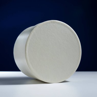 Mavi arka planda beyaz yuvarlak kutu ve beyaz masa.