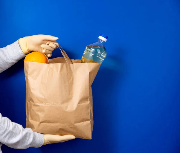 Las manos sostienen la bolsa de comida. Comida para donaciones. .. Entrega de comida en una bolsa ecológica . — Foto de Stock