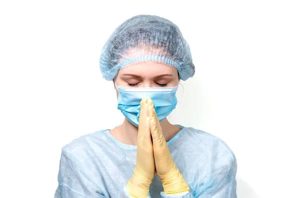 Μια νεαρή γιατρός με ιατρικό φόρεμα έσφιξε τα χέρια της στην προσευχή.. — Φωτογραφία Αρχείου