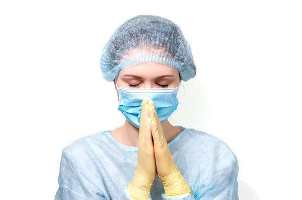 Tıp kıyafetli genç bir doktor dua ederken ellerini sıktı..