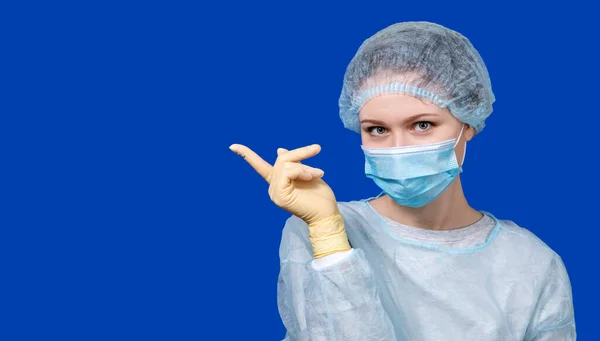 A young doctor in a medical uniform points to a poster. — Stock Photo, Image