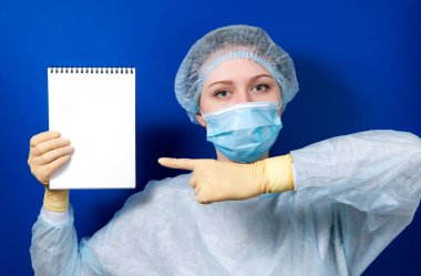 Kadın doktor defterdeki yazıya işaret ediyor..