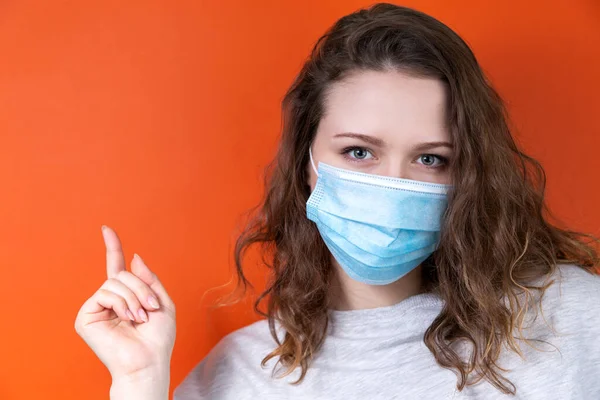 Un médico joven con una máscara médica señala un póster . —  Fotos de Stock