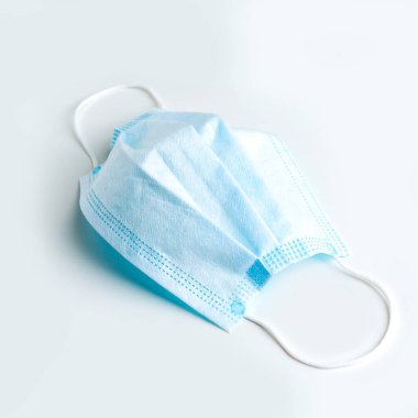 Yazmak için yeri olan beyaz bir masada tıbbi bir maske. Tıbbi konsept.