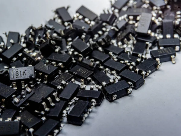 Primo piano astratto dei componenti a semiconduttore per computer con chip a montaggio superficiale sparso — Foto Stock