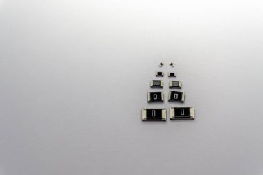 Abstract close-up of scattered various size SMT chip resistors power electronics components isolated on white background