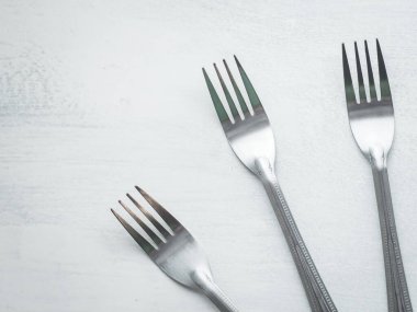 Beyaz arkaplanla boyanmış bir köy tahtasında üç çatal.