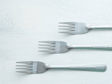 Beyaz arkaplanla boyanmış bir köy tahtasında üç çatal.