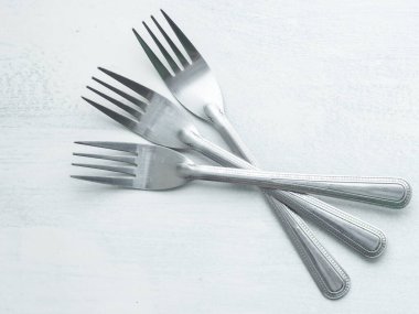 Beyaz arkaplanla boyanmış bir köy tahtasında üç çatal.