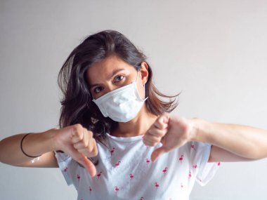 Genç Çekici Kahverengi Saçlı Latin / Tek kullanımlık Yüz Maskesini Öksürük, Grip, Virüs, Başparmağıyla Virüs Koruması İçin Kullanan Kadın