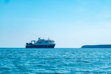 Anticosti Adası, Quebec / Kanada - 16 Temmuz 2018: Vagon ve konteynır taşıyan birkaç katlı büyük bir gemi açık bir günde okyanusta yol alıyor