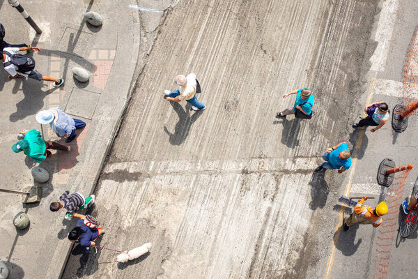 Медельин, Антиокия / Колумбия - 19 ноября 2019 года: Люди переходят улицу, идут вверх и вниз по тротуару
