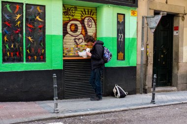 Madrid, Madrid / İspanya - 26 Mart 2015: Plastik Torba ve Karton Kutudan Ayakta Yiyen Genç Adam