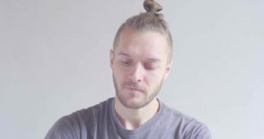 Genç sarı saçlı, beyaz erkek. Ellerindeki tuvalet kağıdına hapşırıyor. 
