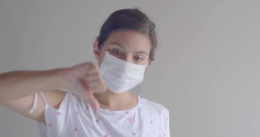 Genç Çekici Kahverengi Saçlı Latin / Tek kullanımlık Yüz Maskesini Öksürük, Grip, Virüs, Başparmağıyla Virüs Koruması İçin Kullanan Kadın
