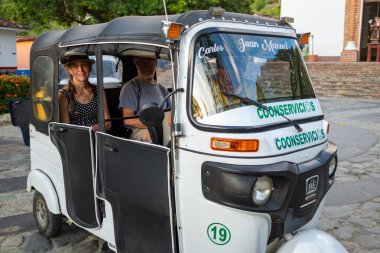 Sucre, Antioquia / Kolombiya - 25 Ocak 2020: Dusk 'taki Central Plaza' da bir Tuk-tuk 'ta bekleyen iki yolcu