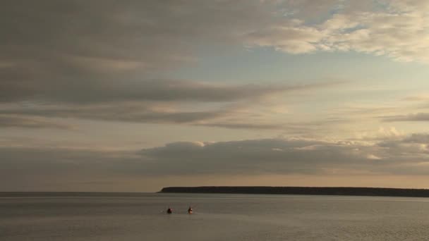 夕日の海にパドルを持つカヤックで2人 — ストック動画