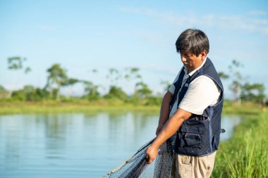 Yapacani, Santa Cruz / Bolivya - 30 Mart 2016: Balık Çiftçisi Tambaqui ve Pacu Balıklarını Yakalamak İçin Ağla Çalışıyor (Serrasalmus) Balık havuzlarından Kova Satıcılığına