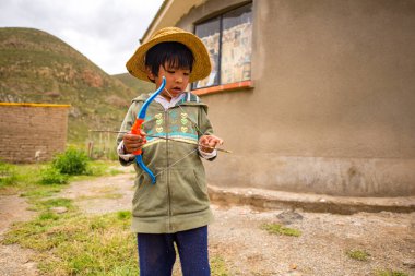 Poopo, Oruro / Bolivya - 14 Şubat 2018: Genç Yerli Uru Çocuk Oyuncak Yay ve Ok ile Oynuyor