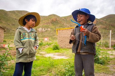 Poopo, Oruro / Bolivya - 14 Şubat 2018: Genç Yerli Uru Çocuk Oyuncak Yay ve Ok ile Başka Bir Çocuğun Yanında Oynuyor