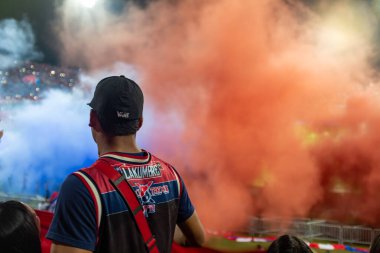 Medellin, Antioquia / Kolombiya - 6 Kasım 2019: Siyah Şapka Giyen Genç Gece Futbol Kupası 'nda Kızıl ve Mavi Duman Stadyumuna Fırladı