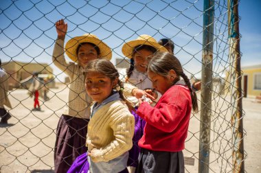 Vilaneque, Oruro / Bolivya - 6 Kasım 2017: Geleneksel Uru Giysilerindeki Küçük Yerli Öğrenci Kızlar Grubu Okul Bahçesindeki Kameraya Bakınız
