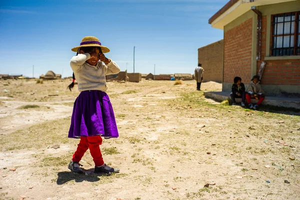 Vilaneque Oruro Bolivia 2017年11月6日 一名身着传统乌鲁族服装的小女孩用手捂住脸 不愿在干旱的土地上看到房子旁边的相机 — 图库照片