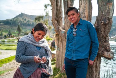 Achocalla, La Paz / Bolivya - 29 Ekim 2016: Genç Aymara Yerli Kadın ve Erkek Ağaçta Gergin Gülen, Küçük Göl kenarında Flört Ediyor