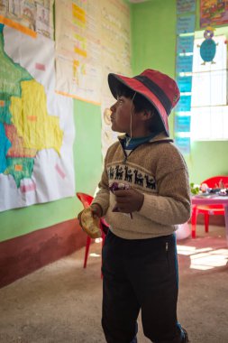 Jesus de Machaca, La Paz / Bolivya - 28 Temmuz 2016: Yerel Aymara Çocuğu Köy Okulu Sınıfının İçinde Ekmek Yiyor