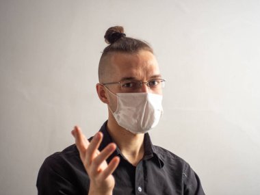 Siyah tişörtlü, tek kullanımlık yüz maskesi takan genç, sarı saçlı, beyaz erkek Covid-19 için yakalanan, grip, virüs, viral koruma.