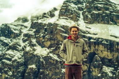 Genç Kafkas Turist pozu Kar Kapaklı Dağ Şapkalı ve Andean Gömlekli ve Gri Ceketli