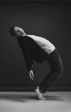Fashion stylish man posing and dancing in the studio on a black background.