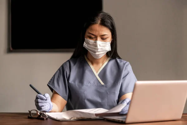 Asyalı doktor doküman yazar. Bulaşıcı derecede tehlikeli. Eldiven koruması. Hastanede çalışıyorum. Tıp konsepti. Virüs. Test et