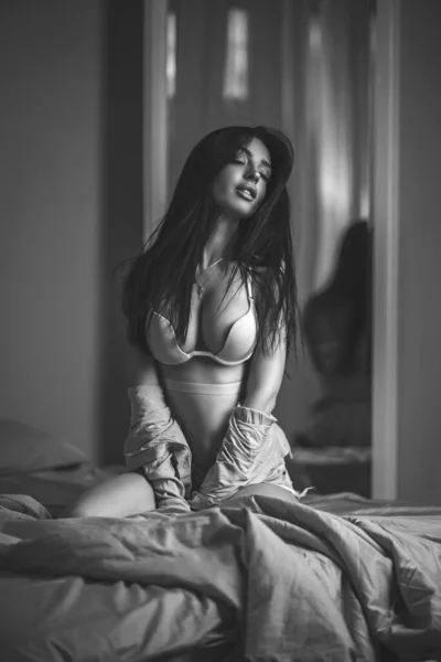 穿着内衣和衬衫的美女站在靠近镜子的卧室里 穿着内裤躺在床上的时髦女模特 黑白肖像画 — 图库照片