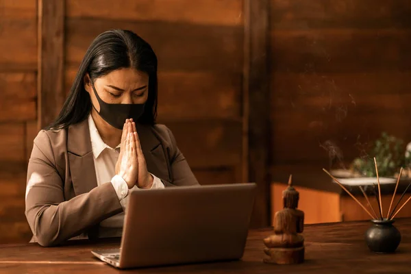 Asian woman praying. Homemade meditation.Spiritual. Relaxation. Asia religion. Online prayer. Church service