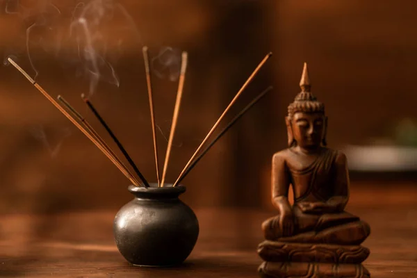 Buda heykelciği ahşap masa ve arka plan. Ev yapımı meditasyon. Ayin. Rahatlama. Asya dini