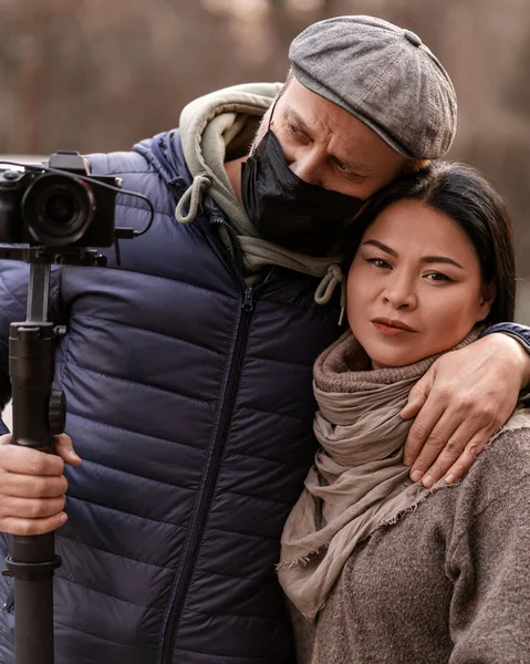 Man photographer with camera street portrait. Casual couple street style. Outdoors lifestyle. Journalist in medical mask. Operator. Hipster stylish male. Creative hobie. Attractive trendy woman