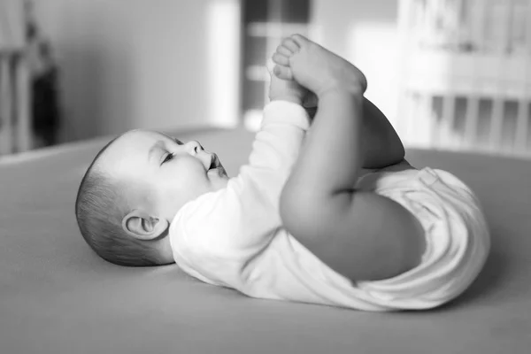 Šťastné dítě hraje s nohama — Stock fotografie