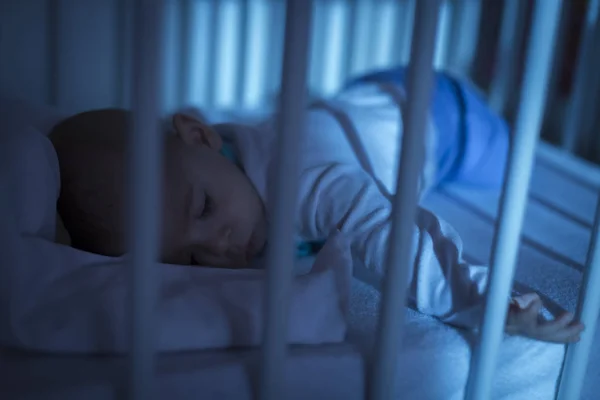 Adorável bebê dormindo em azul à noite — Fotografia de Stock