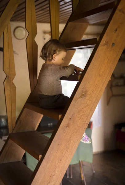 Ребенок сидит на деревянной лестнице — стоковое фото