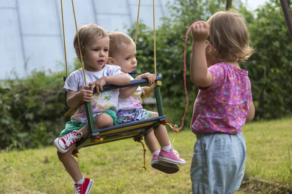 İki küçük kız kardeşi bir ablası sallanan