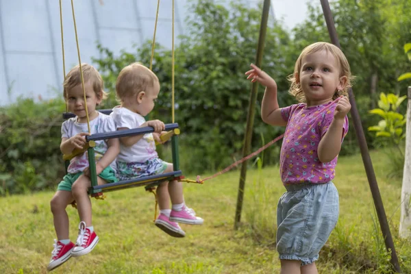 İki küçük kız kardeşi bir ablası sallanan