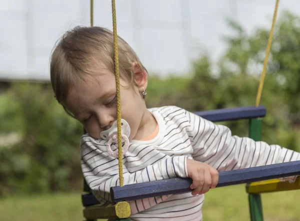 Fatigué beau bébé dormir sur une balançoire — Photo