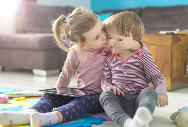 İki küçük kız kardeş evde tablet kullanmak