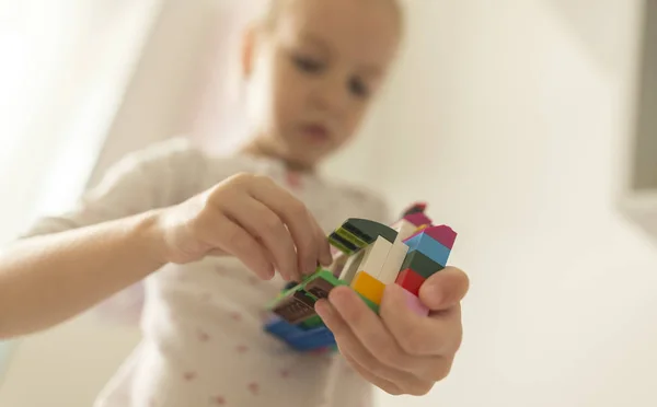 Милая забавная дошкольница, играющая со строительной игрушкой — стоковое фото